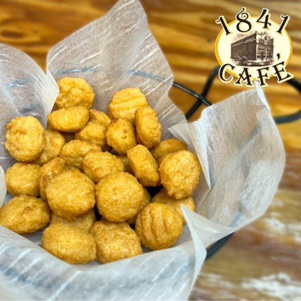 A basket of golden-brown fried cheese curds from 1841 Cafe, lined with white paper.