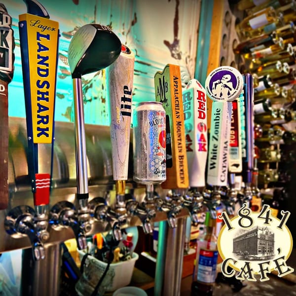 A row of various beer taps, including Landshark Lager, Miller Lite, and Catawba Brewing, at 1841 Cafe.