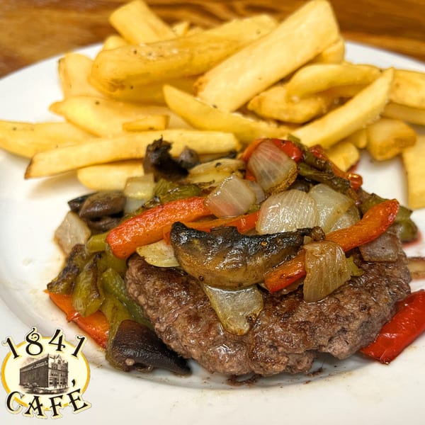 A hamburger patty topped with sautéed onions, mushrooms, and bell peppers, served with thick-cut fries.
