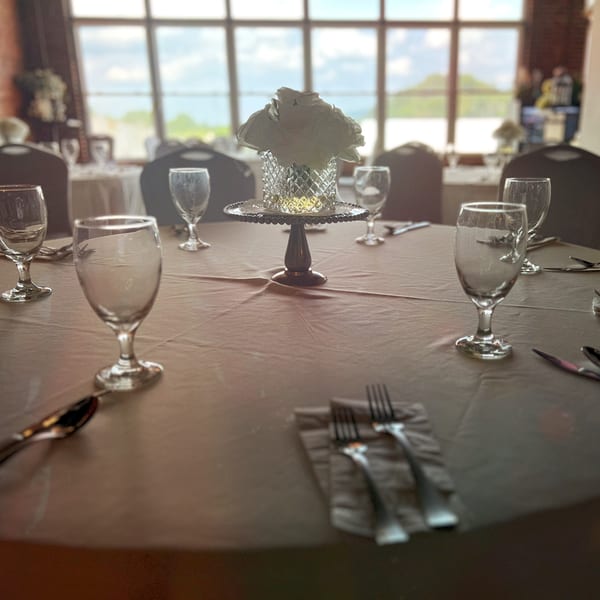 A set table with wine glasses, silverware, and a white floral centerpiece at 1841 Cafe.