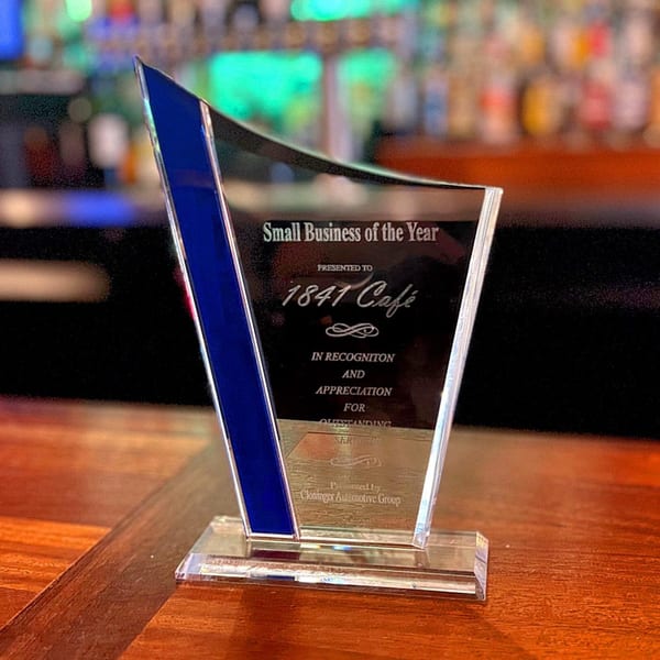 A clear acrylic award with a blue stripe, recognizing 1841 Café as "Small Business of the Year".